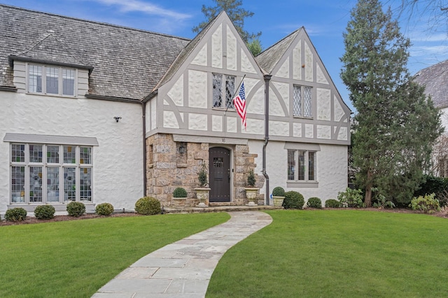 tudor-style house with a front yard