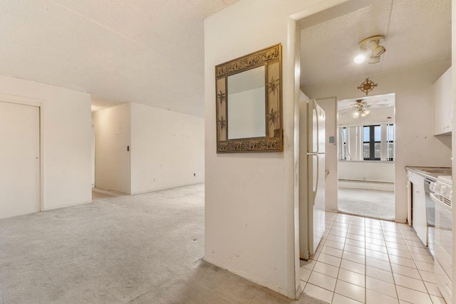 hallway featuring light colored carpet and a textured ceiling