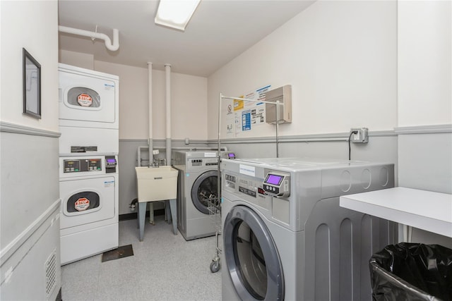 laundry room featuring independent washer and dryer, stacked washer and dryer, and sink