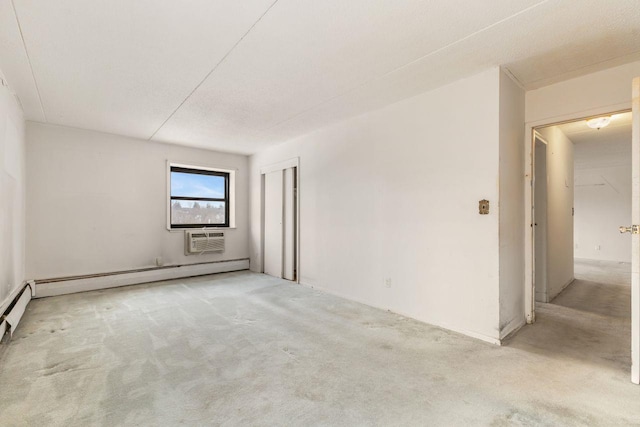 empty room featuring baseboard heating, light colored carpet, and a wall mounted air conditioner