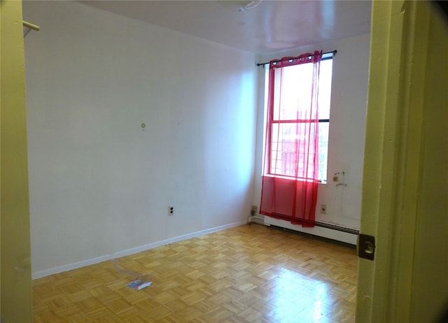 unfurnished room featuring baseboard heating and light parquet floors