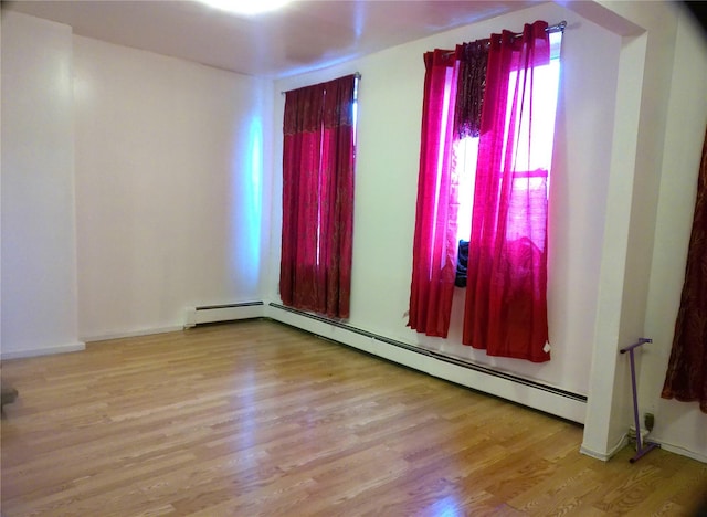 empty room featuring light hardwood / wood-style floors and a baseboard radiator