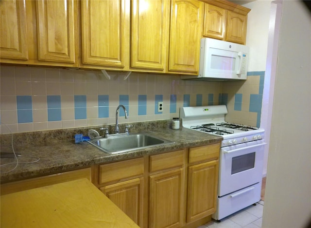 kitchen featuring white appliances, dark stone counters, sink, backsplash, and light tile patterned flooring