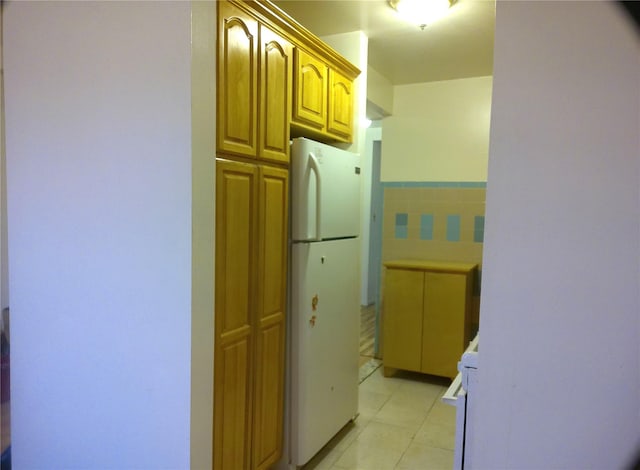 kitchen with backsplash, white fridge, and range