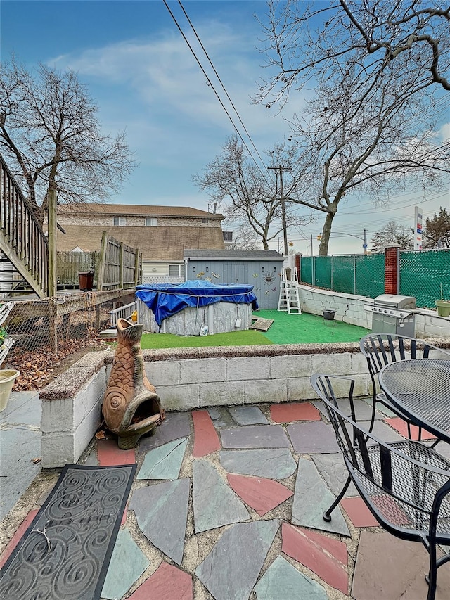 view of patio with a grill and a covered pool