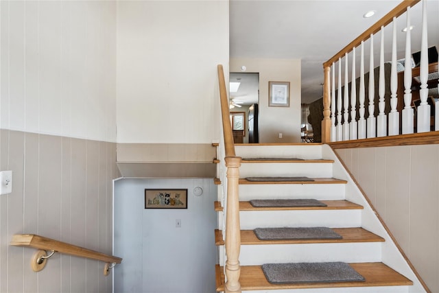 staircase featuring wooden walls