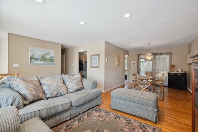 living room with baseboard heating and light hardwood / wood-style flooring