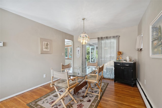 dining area featuring a baseboard radiator, dark hardwood / wood-style flooring, and a notable chandelier