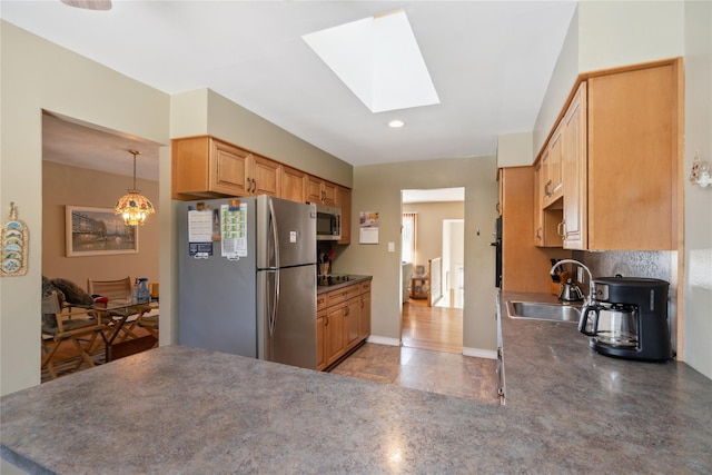 kitchen featuring pendant lighting, sink, a skylight, stainless steel appliances, and light brown cabinetry