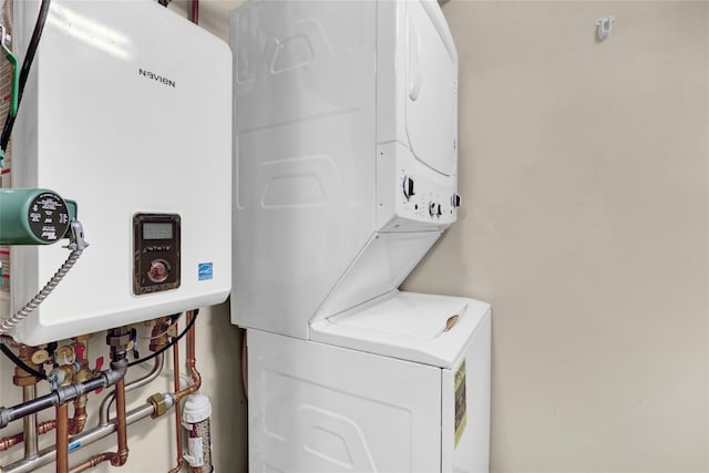 laundry area with stacked washer and clothes dryer and tankless water heater