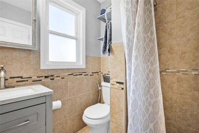 bathroom with toilet, tile walls, a shower with curtain, and vanity