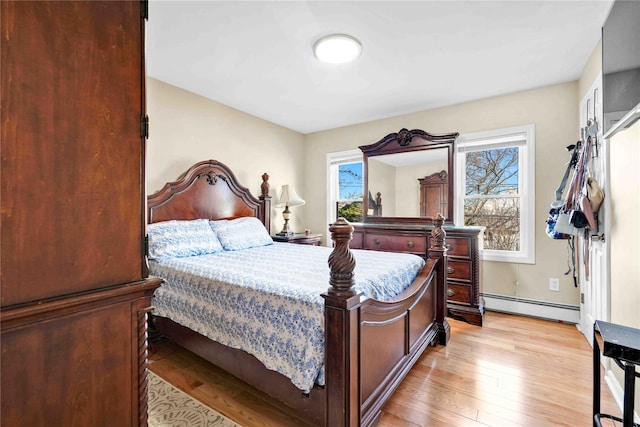 bedroom with light hardwood / wood-style flooring and a baseboard radiator