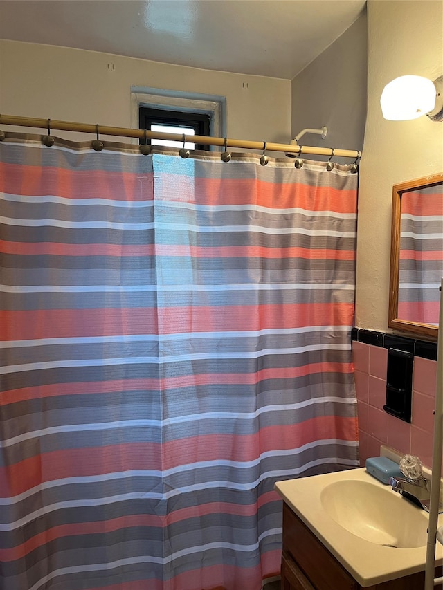 bathroom with tasteful backsplash, vanity, and tile walls