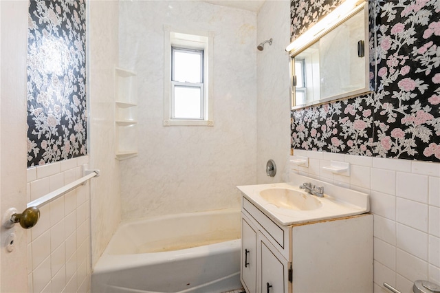 bathroom with tile walls, vanity, and shower / bathing tub combination