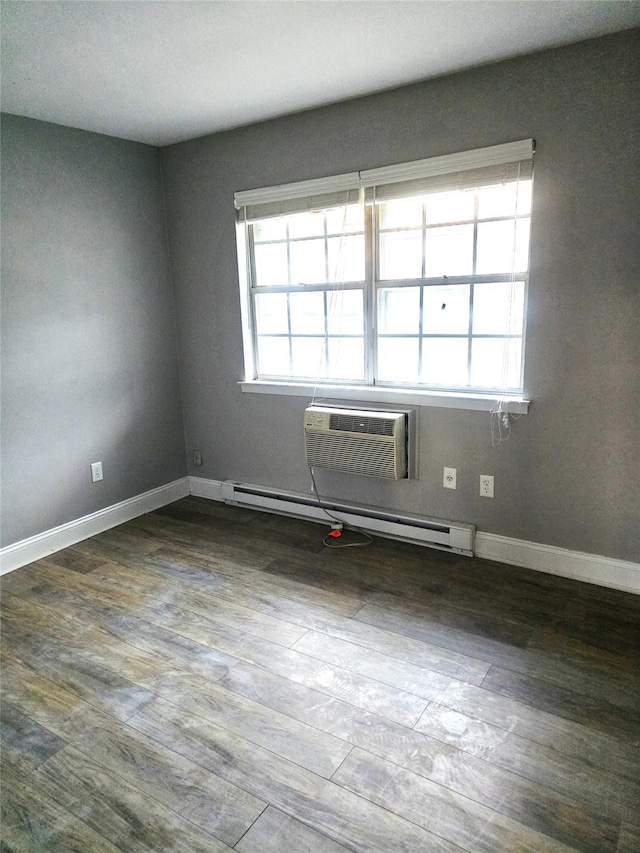 empty room with baseboard heating, wood-type flooring, and an AC wall unit