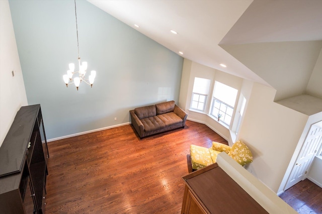 living room featuring dark hardwood / wood-style floors, lofted ceiling, and an inviting chandelier