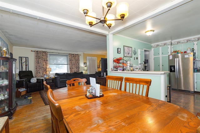 dining space with crown molding, dark hardwood / wood-style flooring, and an inviting chandelier