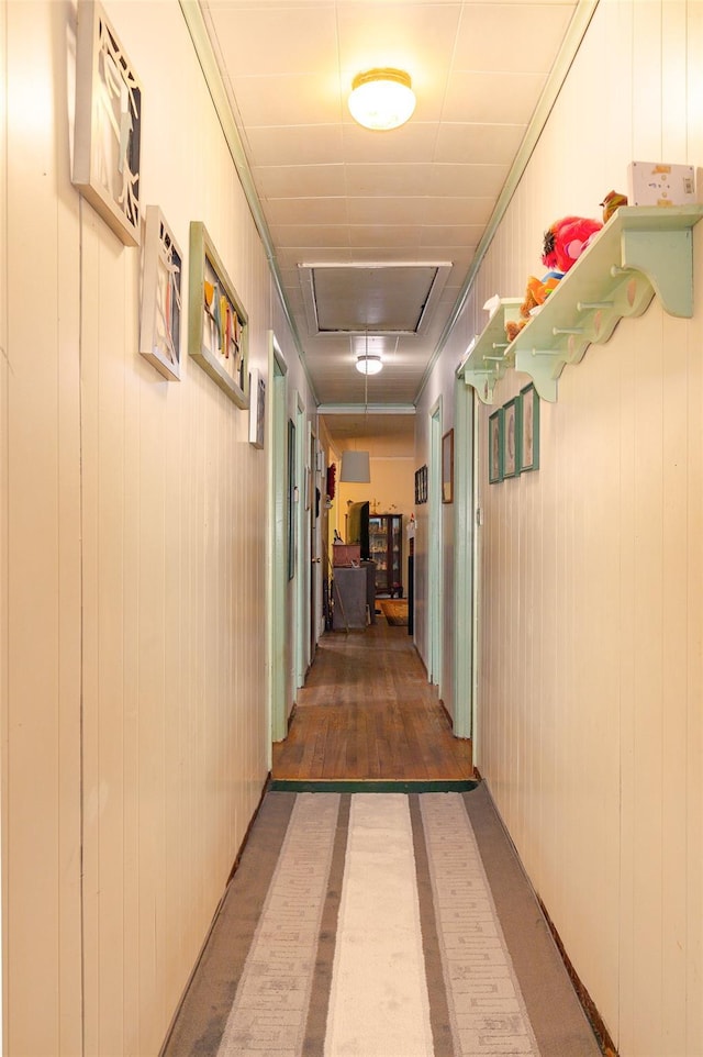 corridor featuring ornamental molding and wooden walls