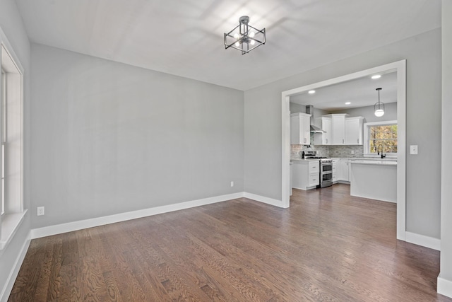 unfurnished living room featuring recessed lighting, dark wood-style flooring, and baseboards