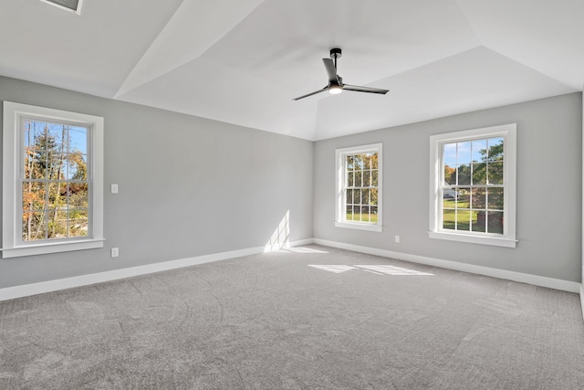 empty room featuring lofted ceiling, carpet floors, and baseboards