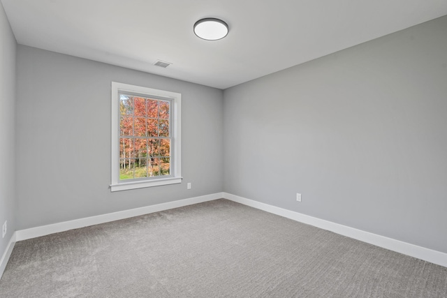 carpeted empty room with visible vents and baseboards