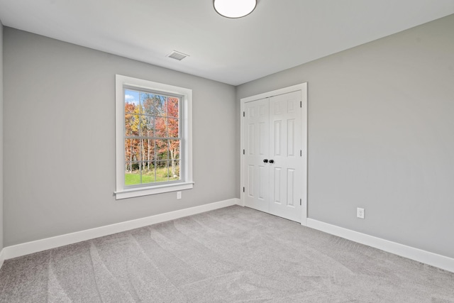 spare room featuring visible vents, baseboards, and carpet flooring