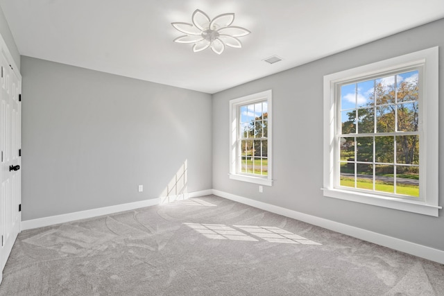 carpeted empty room with visible vents and baseboards