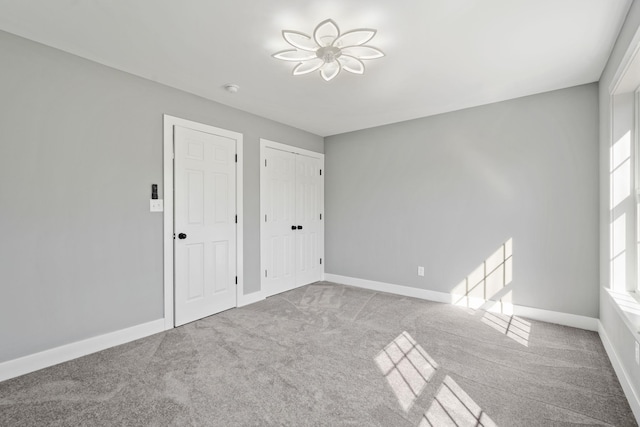 unfurnished bedroom featuring carpet flooring and baseboards