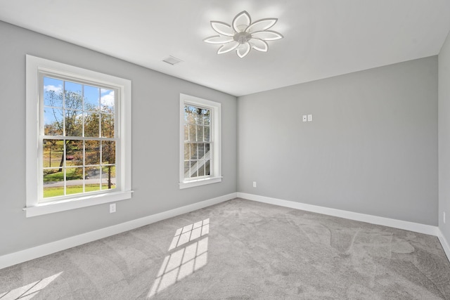 empty room featuring a healthy amount of sunlight, carpet, and baseboards