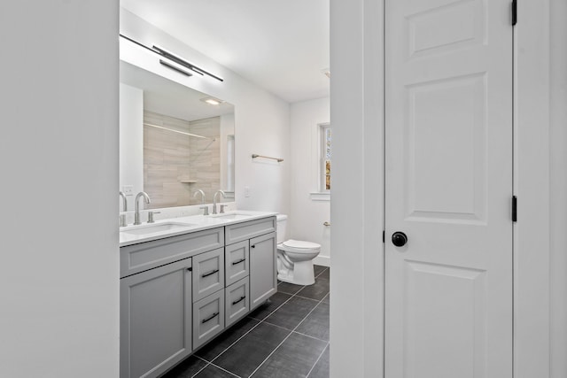 full bath with double vanity, tile patterned flooring, a sink, and toilet