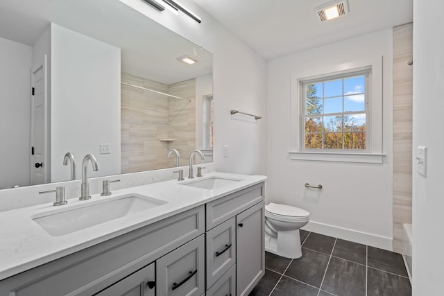 full bathroom with toilet, baseboards, visible vents, and a sink