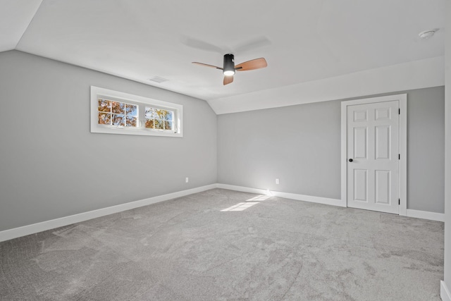 carpeted spare room with lofted ceiling, ceiling fan, and baseboards