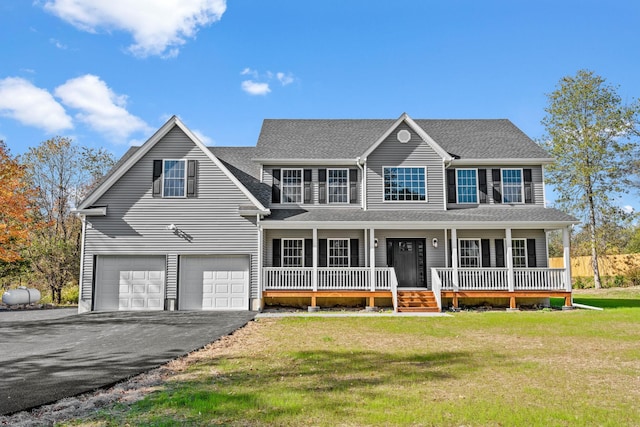 colonial home with roof with shingles, a porch, a garage, driveway, and a front lawn