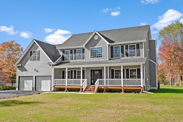 colonial house with covered porch, a front yard, a balcony, a garage, and driveway