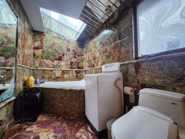 bathroom featuring toilet, vaulted ceiling, and a washtub