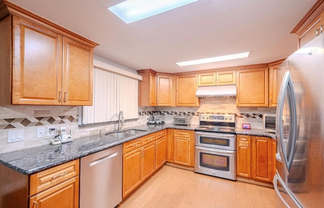 kitchen with appliances with stainless steel finishes, decorative backsplash, and sink