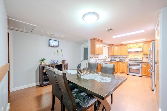 dining room with light hardwood / wood-style flooring and sink