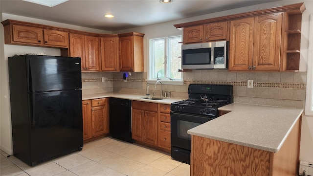 kitchen with black appliances, sink, light tile patterned floors, a baseboard radiator, and decorative backsplash