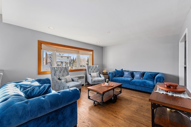 living room featuring radiator heating unit, wood finished floors, and recessed lighting