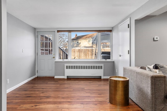 interior space with radiator heating unit, wood finished floors, and baseboards