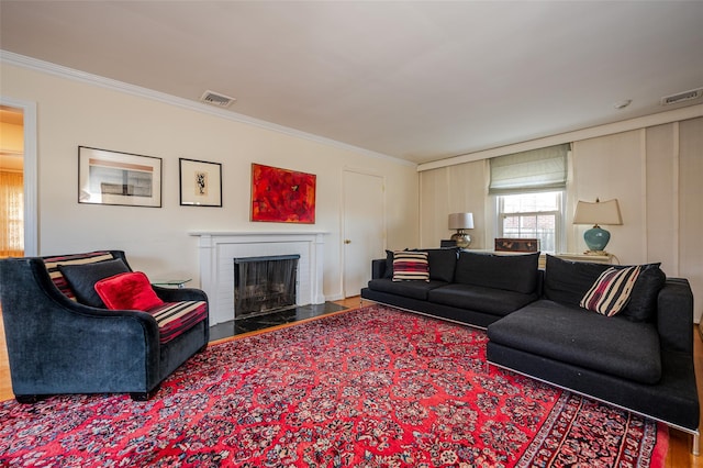 living room featuring a brick fireplace, ornamental molding, and hardwood / wood-style floors