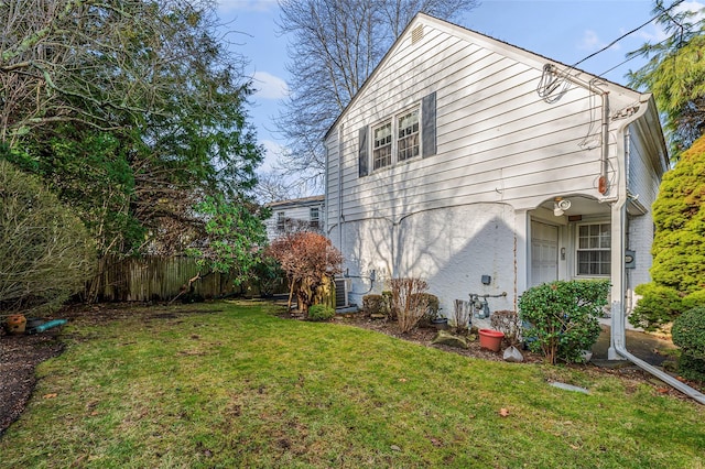 rear view of house with a lawn and central air condition unit