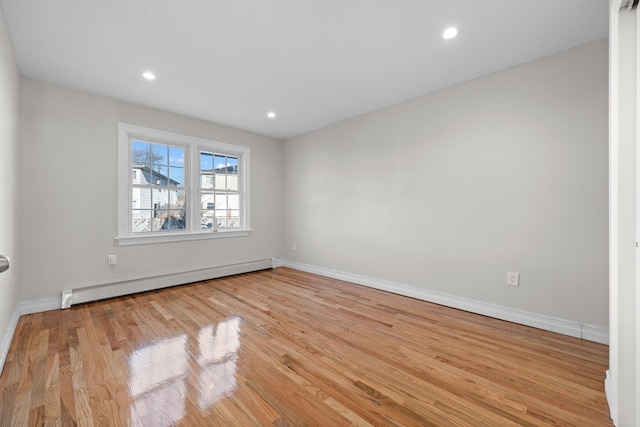 spare room with a baseboard radiator and light hardwood / wood-style flooring