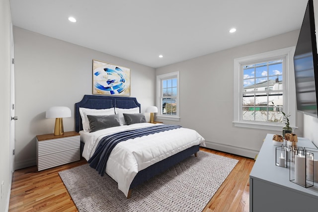 bedroom featuring a baseboard radiator and light hardwood / wood-style flooring