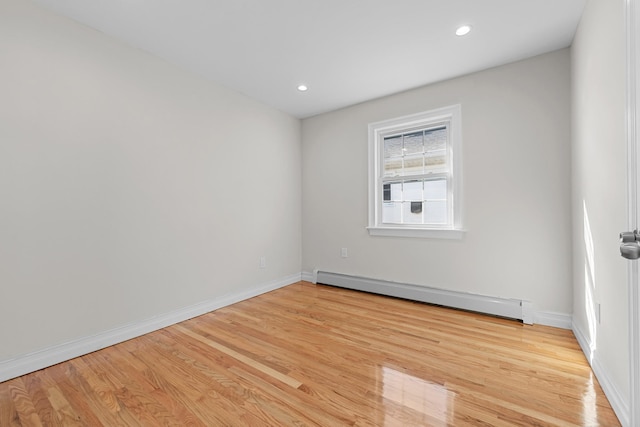 empty room with a baseboard radiator and light wood-type flooring