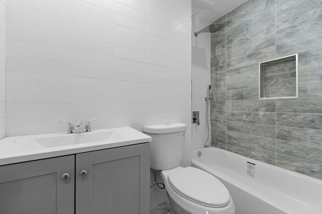 full bathroom with toilet, tiled shower / bath combo, vanity, and tile walls