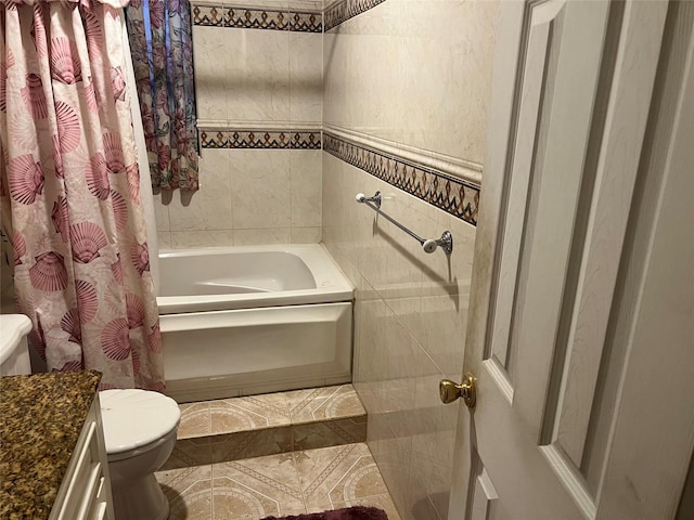 full bathroom with vanity, toilet, shower / bath combo with shower curtain, and tile walls