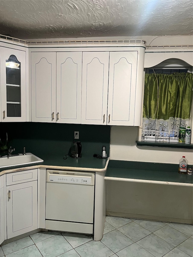 kitchen with dishwasher, sink, white cabinets, and a textured ceiling