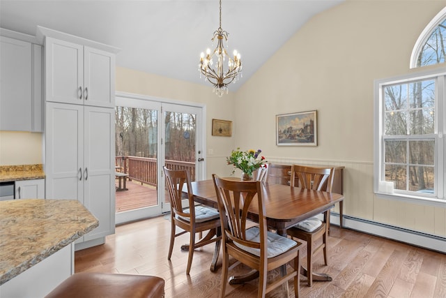 dining room featuring vaulted ceiling, light hardwood / wood-style floors, a baseboard radiator, and a notable chandelier