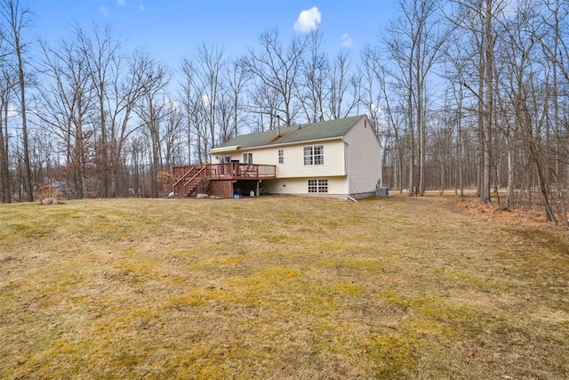 rear view of property with a deck and a lawn